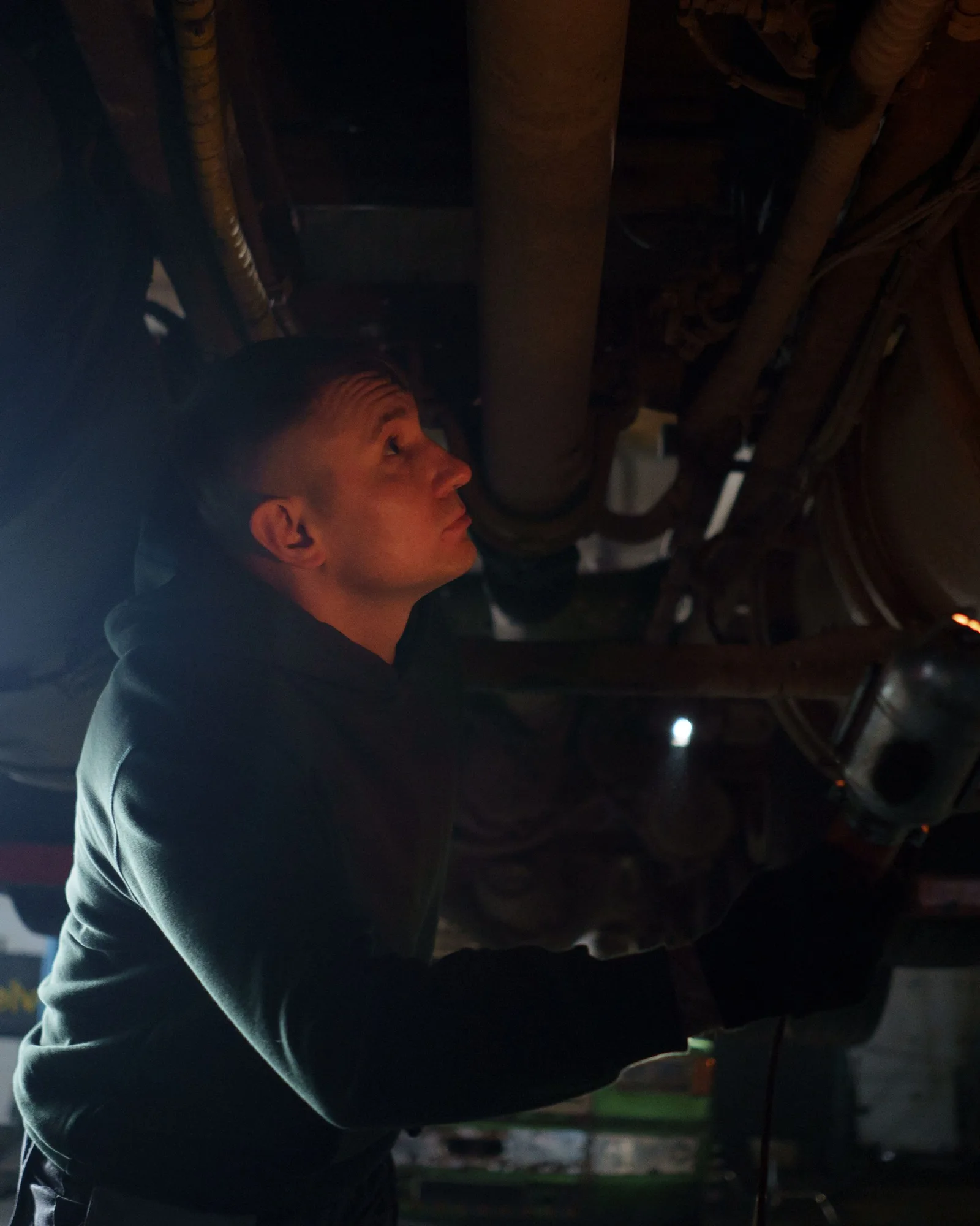 Technicien au travail sous le tableau de bord d’une voiture